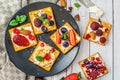 Set of crackers with various fruit close-up on black stone plate Royalty Free Stock Photo