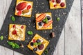 Set of crackers with various fruit close-up on black stone plate Royalty Free Stock Photo