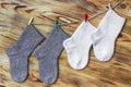 Set of cute knitted cashmere newborn baby socks hanged on pins against wooden background Royalty Free Stock Photo
