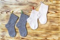 Set of cute knitted cashmere newborn baby socks hanged on pins against wooden background Royalty Free Stock Photo