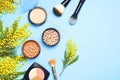 Set of decorative cosmetics for make-up Powder Rouge Eyeshadow Corrector Brushes and flowers of mimosa on blue background. Makeup Royalty Free Stock Photo