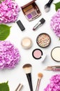 Set of decorative cosmetics mascara powder lipstick eyeshadow blush makeup brush pink hydrangea flowers on light background top Royalty Free Stock Photo