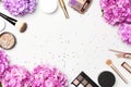 Set of decorative cosmetics mascara powder lipstick eyeshadow blush makeup brush pink hydrangea flowers star confetti on light Royalty Free Stock Photo