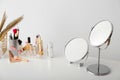 Set of decorative cosmetics and mirrors on dressing table Royalty Free Stock Photo