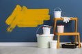 Set with decorator`s tools and paint on floor near blue wall Royalty Free Stock Photo