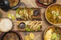Set of delicious asian food dishes with wooden chopsticks, wok noodles with shrimp, rice in bowl, ramen with beef and boiled egg Royalty Free Stock Photo