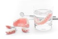 Set of Denture in glass of water and tools on white background Royalty Free Stock Photo