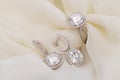 A set of diamond earrings and a diamond ring are displayed on a white cloth Royalty Free Stock Photo