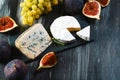 Set of different cheeses on a wooden rustic background. cheese plate on the table. Variety of cheeses with honey, grapes, walnuts Royalty Free Stock Photo