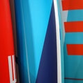 Set of different color surf boards in a stack. Surf boards for rent. Red and Blue Background. Square Photo Royalty Free Stock Photo