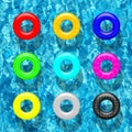 Set of different color swimming rings on blue pool water background. Vector design elements.
