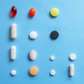 Set of different colorful pills and capsules on blue background. Health care, medical concept. Royalty Free Stock Photo