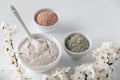 Set of different cosmetic clay mud powders on white background