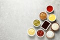 Set of different delicious sauces on grey table, top view