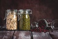 A set of different dried legumes in a glass jar on a dark wooden rustic table. Selective focus. White and red bean, mung beans Royalty Free Stock Photo