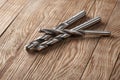 Set of different drill bits on wooden background Royalty Free Stock Photo