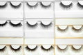 Set with different false eyelashes in packs as background Royalty Free Stock Photo