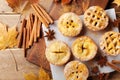 Set of different mini apple pies decorated sugar powder and cinnamon on wooden board top view. Autumn pastry dessert.