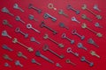 Set of different old keys on red background, top view, closeup. Safety and security concept. Pattern of many keys Royalty Free Stock Photo