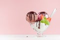 Set of different refreshing classic creamy ice cream balls in bowl with chocolate sauce, mint, spoon, strawberry on white wooden.