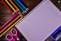 Set of different school stationeries. Notepad, scissors, pensils, on wooden desk. Back to school. Top view Royalty Free Stock Photo