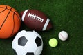 Set of different sport balls on green grass, flat lay Royalty Free Stock Photo