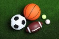 Set of different sport balls on green grass, flat lay Royalty Free Stock Photo