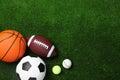 Set of different sport balls on green grass, flat lay. Space for text Royalty Free Stock Photo