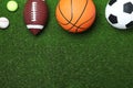 Set of different sport balls on green grass, flat lay. Space for text Royalty Free Stock Photo