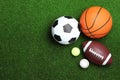 Set of different sport balls on green grass, flat lay. Space for text Royalty Free Stock Photo