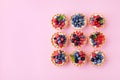 Set of different tartlets or cake with cream cheese, honey and summer berry on pink. Pastry dessert top view. Flat lay