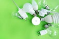 A set of different types of LED lamps isolated on a green background. Energy-saving lamps, in the center the flashlight is turned Royalty Free Stock Photo