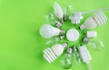 A set of different types of LED lamps isolated on a green background. Energy-saving lamps, a flashlight in the center Royalty Free Stock Photo