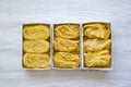 Set of different uncooked pasta in paper boxes on a white wooden table, top view. From above, overhead. Royalty Free Stock Photo