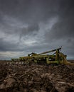 A set of Disc Harrows in a ploughed field under a very heavy sky. Royalty Free Stock Photo