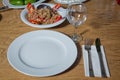 Table setting on wooden table . Dinner place setting. A white plate with silver fork and Wine glasses isolated on wood table. top Royalty Free Stock Photo