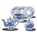 A set of dishes in the gzhel style with blue flowers. Porcelain and earthenware ceramic items for table setting. Teapot, sugar bow
