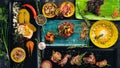 A set of dishes of meat and fresh vegetables and fish on a wooden table. Royalty Free Stock Photo