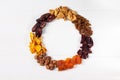 A set of dried berries, fruits and nuts in the form of a wreath hazelnut,pumpkin, cherry, apricot, Apple, dates, on a white