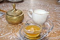 A set for drinking tea, a cup and thrush, covered with bronze lids, close-up view. Royalty Free Stock Photo