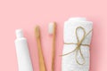 Set of eco-friendly toothbrushes, toothpaste and other tools on pink background.