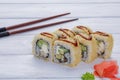 Set of eight rolls with eel, sesame, avocado and philadelphia cheese, decorated with wasabi and ginger on a wooden white backgroun Royalty Free Stock Photo