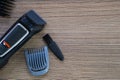 Set of electric hair clippers and attachments on wooden table. Closeup Royalty Free Stock Photo