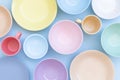 Set of colorful ceramic bowls, plates and cups on blue background. Top view Royalty Free Stock Photo