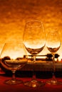 Set of empty glasses for different drinks, warm orange tinted. Empty wine glass, cognac glass and liquor glass/