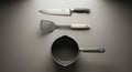 Minimalist kitchen utensils set with chef knife spatula and sauce pan on smooth surface Royalty Free Stock Photo