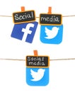 Set of Facebook and Twitter paper icons, which hanging on a rope with tag orange clothespins with chalk written Social Media words Royalty Free Stock Photo