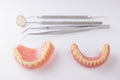 Set of false teeth and dental tools on white background Royalty Free Stock Photo