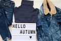 Set of female autumn clothes, modern board with text `Hello autumn`. Top view, from above