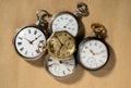 Set of five antique gold and silver pocket watches on beige background. Retro mechanical watch with white dials, hands Royalty Free Stock Photo